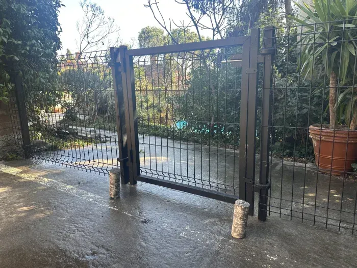 Una puerta de metal está al costado de una carretera.