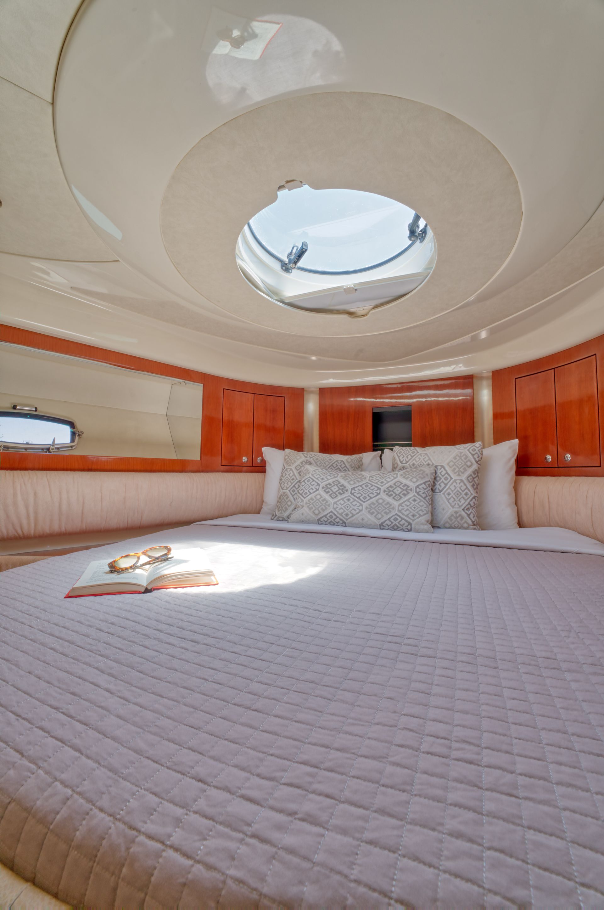 Modern bedroom with a bed, skylight ceiling, and warm orange wood paneling
