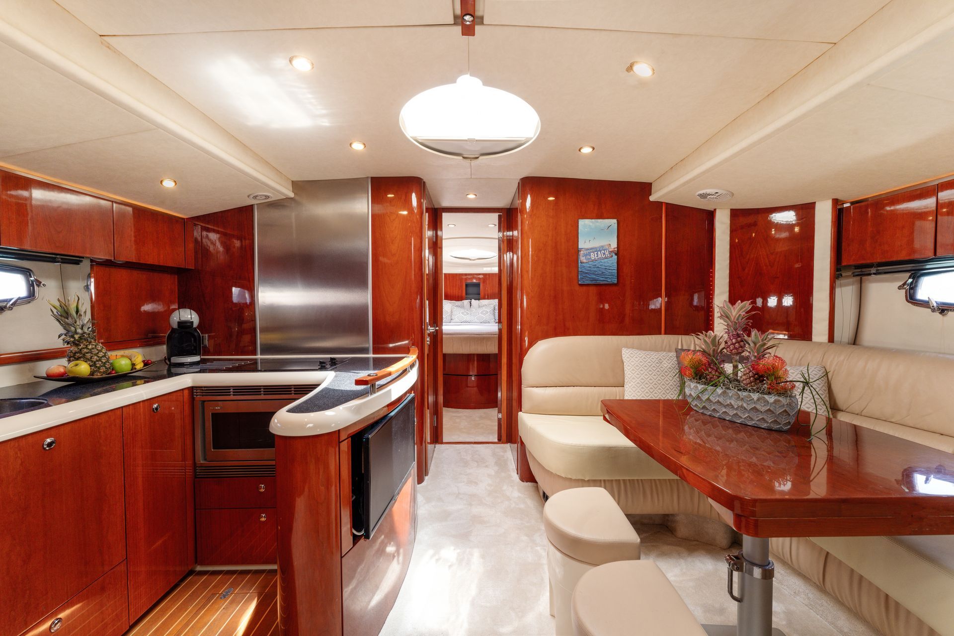 Luxurious yacht interior with wood paneling, galley kitchen, and dining area
