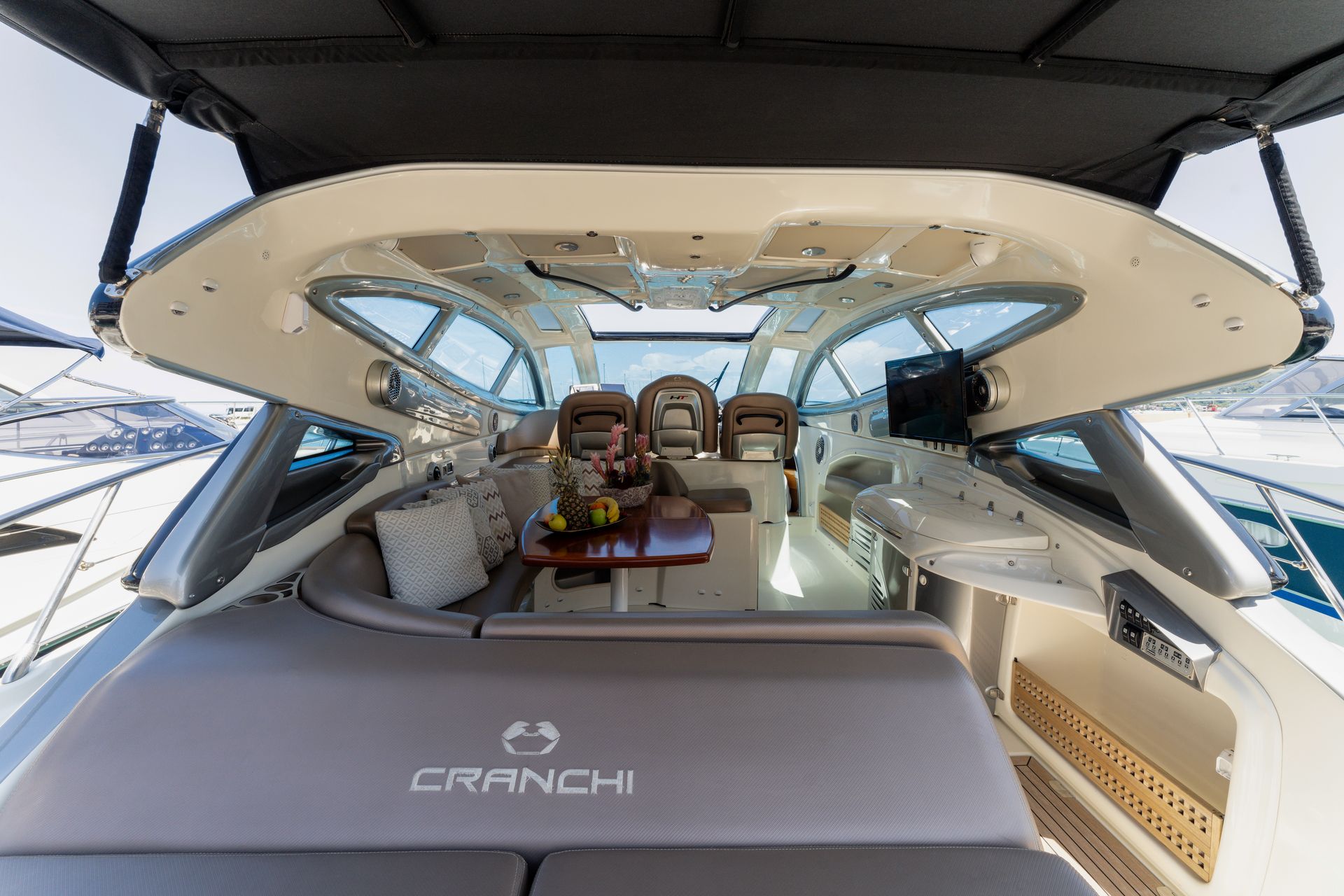 Luxurious yacht cockpit and lounge with cream seating, open canopy, and ocean view