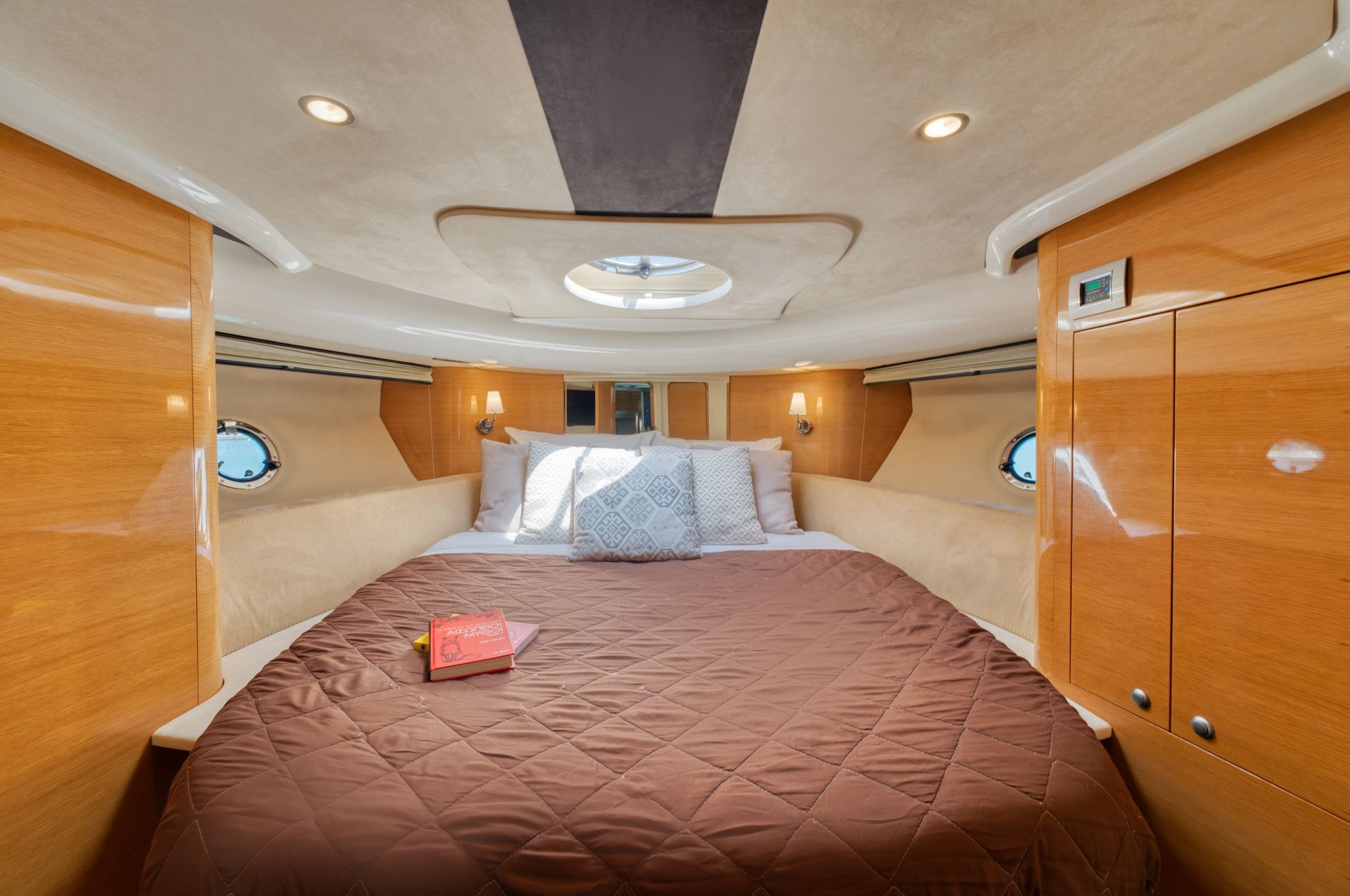Luxurious cabin bedroom with a large bed, wood paneling, and skylight ceiling lights