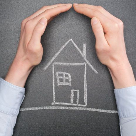 Des mains forment un cadre protecteur autour d'un dessin à la craie d'une maison sur fond gris.