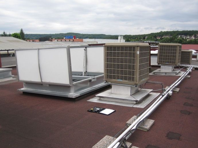 Unités de climatisation et conduits de ventilation sur un toit plat sous un ciel couvert