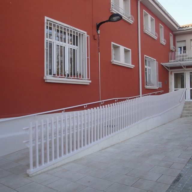 Un edificio rojo con una rampa que conduce a él.