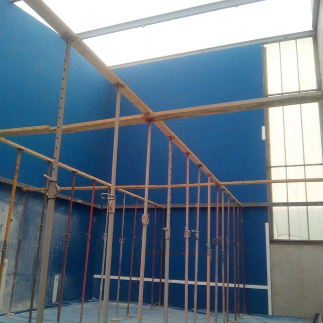 Una habitación con una pared azul y muchos andamios.