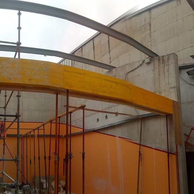 Un edificio en construcción con una viga amarilla en el medio.