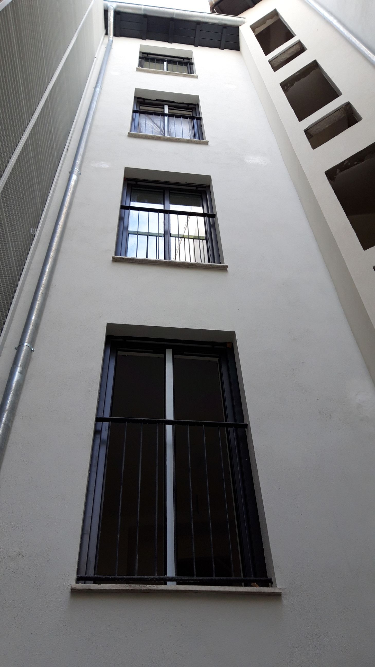 Mirando hacia arriba a un edificio con muchas ventanas