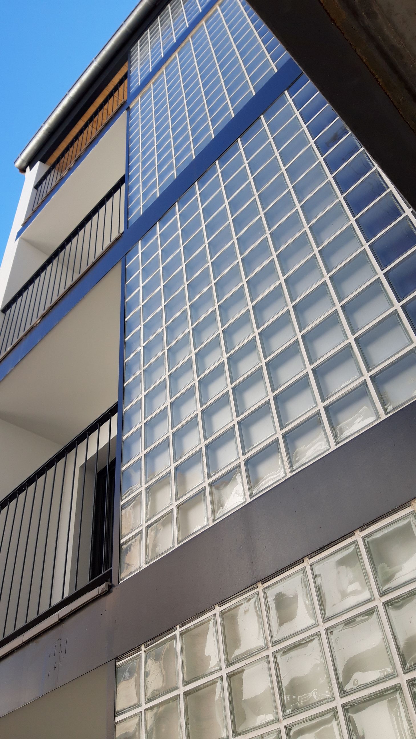 Mirando hacia arriba a un edificio con bloques de vidrio transparente
