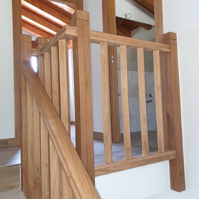 Una barandilla de madera en un tramo de escaleras de una casa.