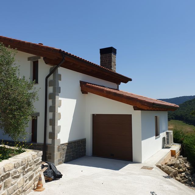 Una casa blanca con una puerta de garaje marrón