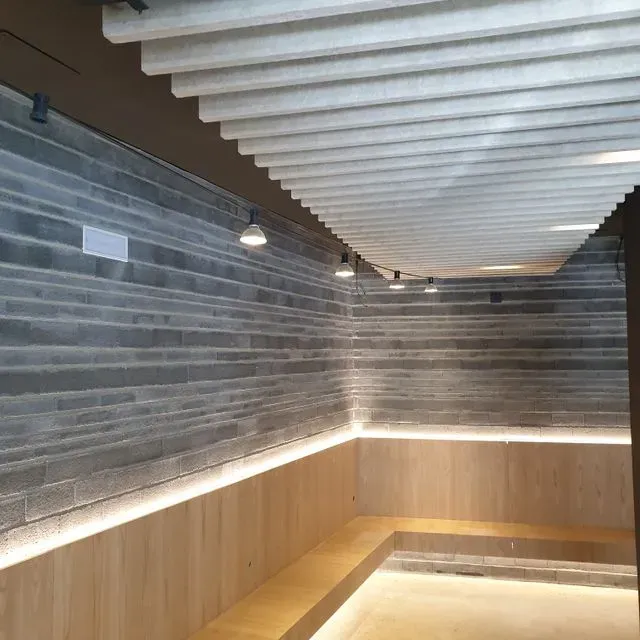 Una habitación con una pared de ladrillo y un banco de madera.