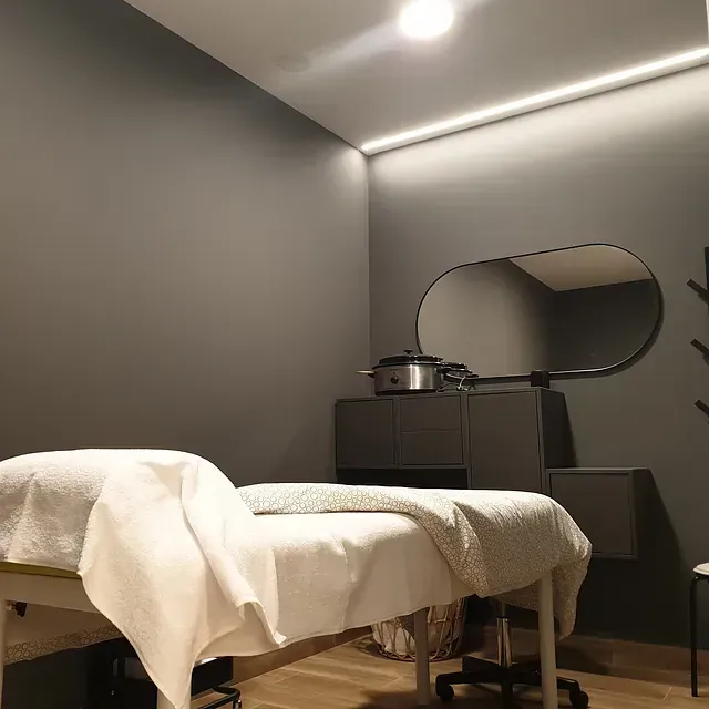 Una habitación con una cama y un espejo en la pared