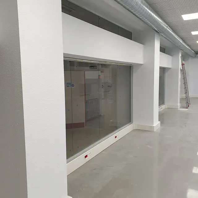 Una habitación grande con muchas ventanas y una escalera.