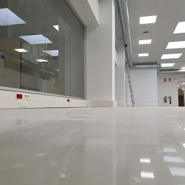 Una habitación grande con muchas ventanas y una escalera.