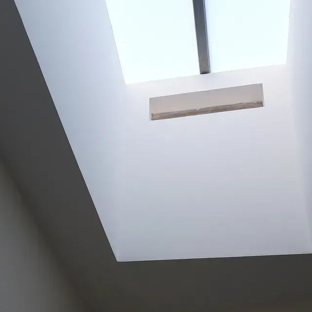 Mirando hacia arriba a un tragaluz en una habitación blanca