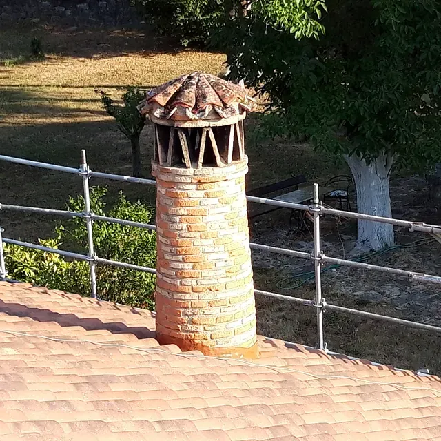 Una chimenea de ladrillo sobre un techo de tejas