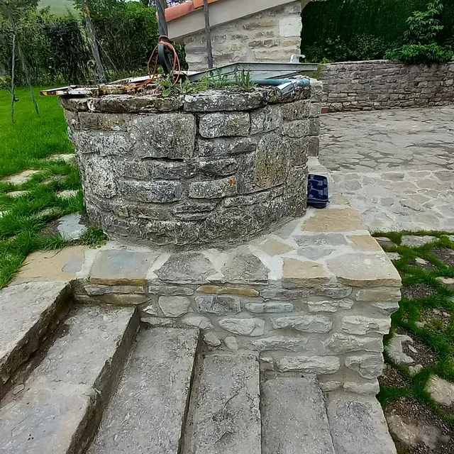 Un pozo de piedra con escaleras que conducen hasta él.