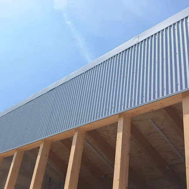 Un edificio con techo de metal y vigas de madera