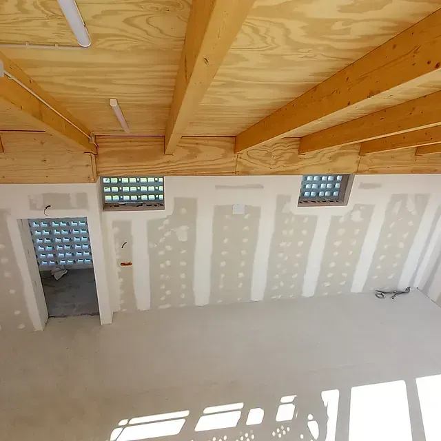 Una habitación vacía con techo de madera y paredes blancas.
