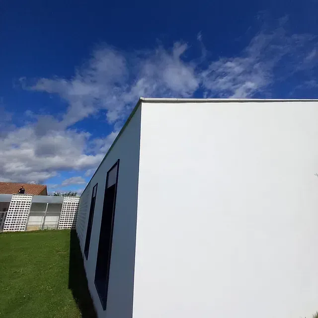 Un edificio blanco con un cielo azul al fondo.