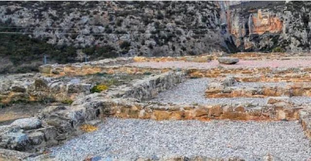 Un edificio de piedra muy antiguo con muchas rocas en el fondo.