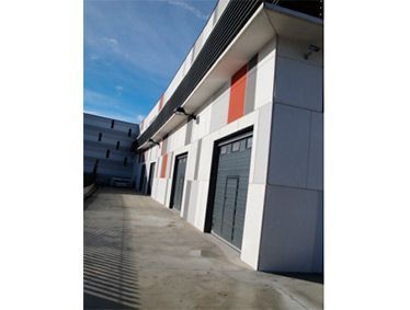 Un edificio grande con muchas puertas y un camino de entrada que conduce a él.