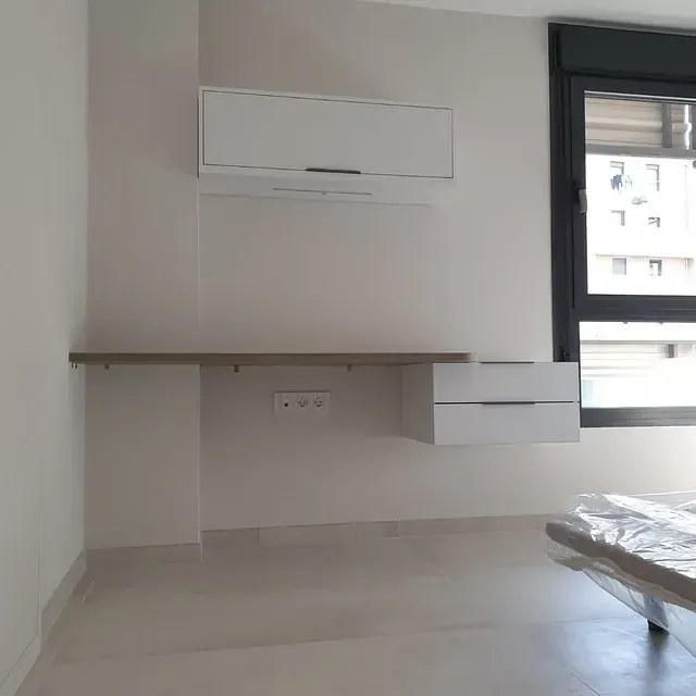 Una habitación vacía con un escritorio y una ventana.