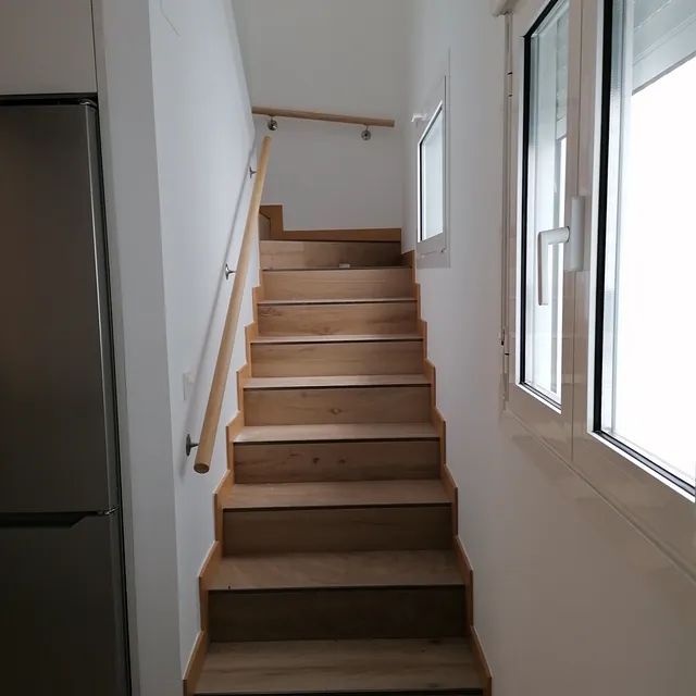 Un conjunto de escaleras de madera que conducen al segundo piso de una casa.