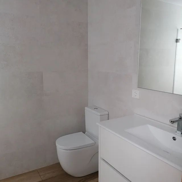 Un baño con inodoro, lavabo y espejo.