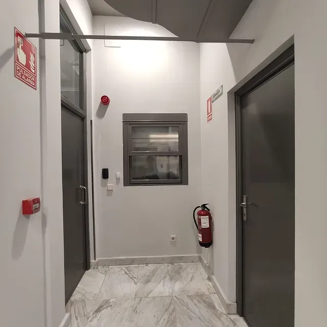 Un pasillo con un extintor en la pared.