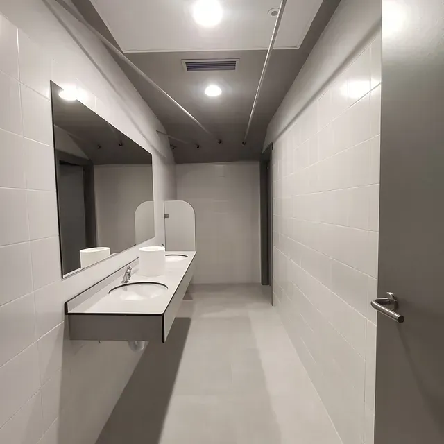 Un baño con dos lavabos y un espejo en la pared.