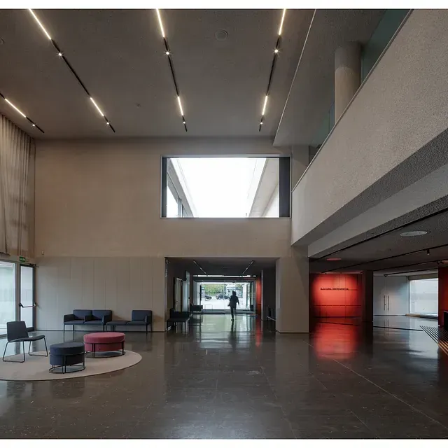 Una habitación grande con una pared roja y una ventana grande.