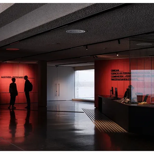 Dos personas de pie en una habitación con un cartel que dice