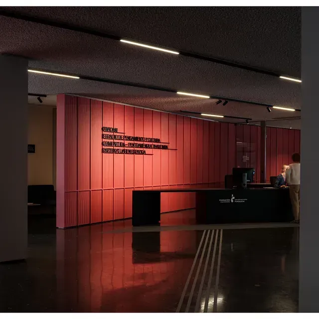 Una habitación con una pared roja y un escritorio negro