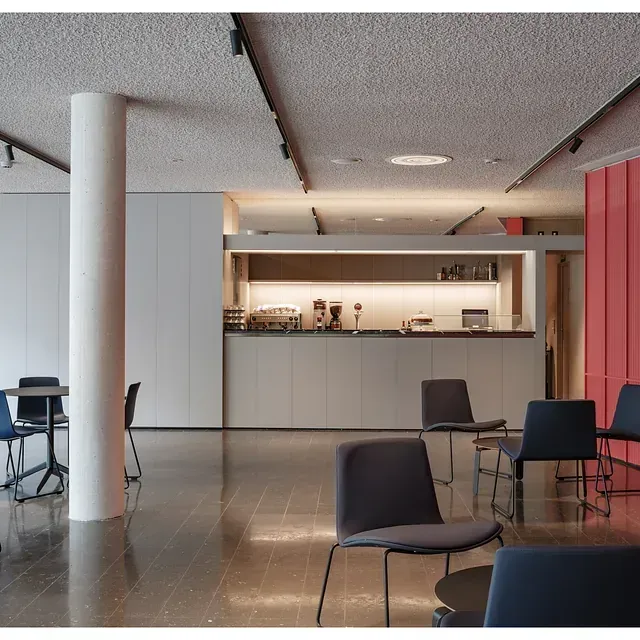 Una habitación con mesas y sillas y un mostrador.