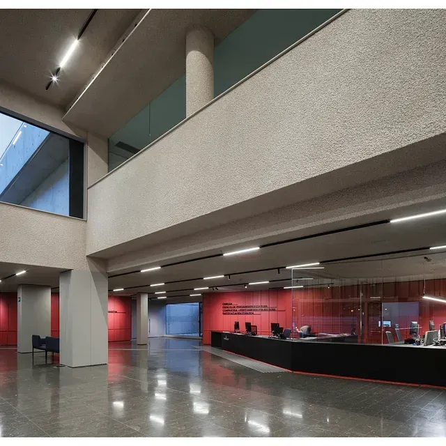 Un gran vestíbulo con una pared roja y un mostrador negro.
