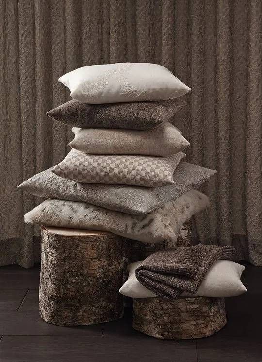 Ein Stapel übereinander gestapelter Kissen auf einem Holzstumpf.