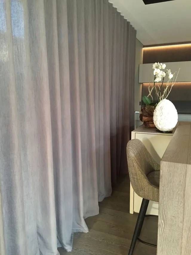 Auf dem Tisch im Zimmer steht eine Vase mit Blumen.