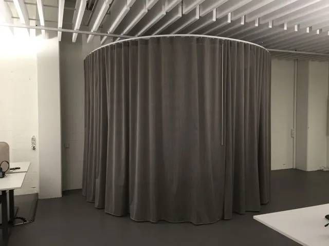 In der Mitte des Raumes befindet sich ein runder Vorhang.
