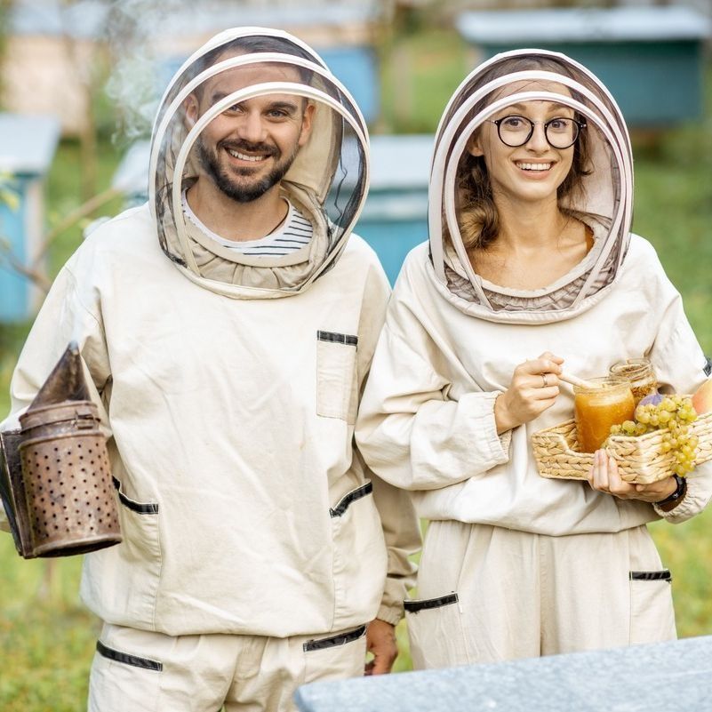 Un hombre y una mujer con trajes de abeja están parados uno al lado del otro.