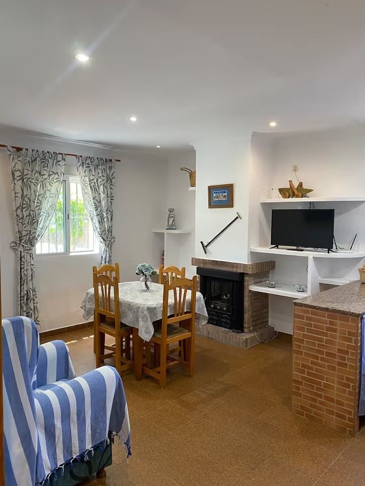 Un acogedor comedor con mesa, sillas y chimenea junto a un televisor.