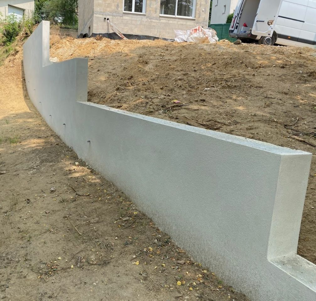 Mur de soutènement sur environ 26 mètres linéaires avec barbacanes et enduit.