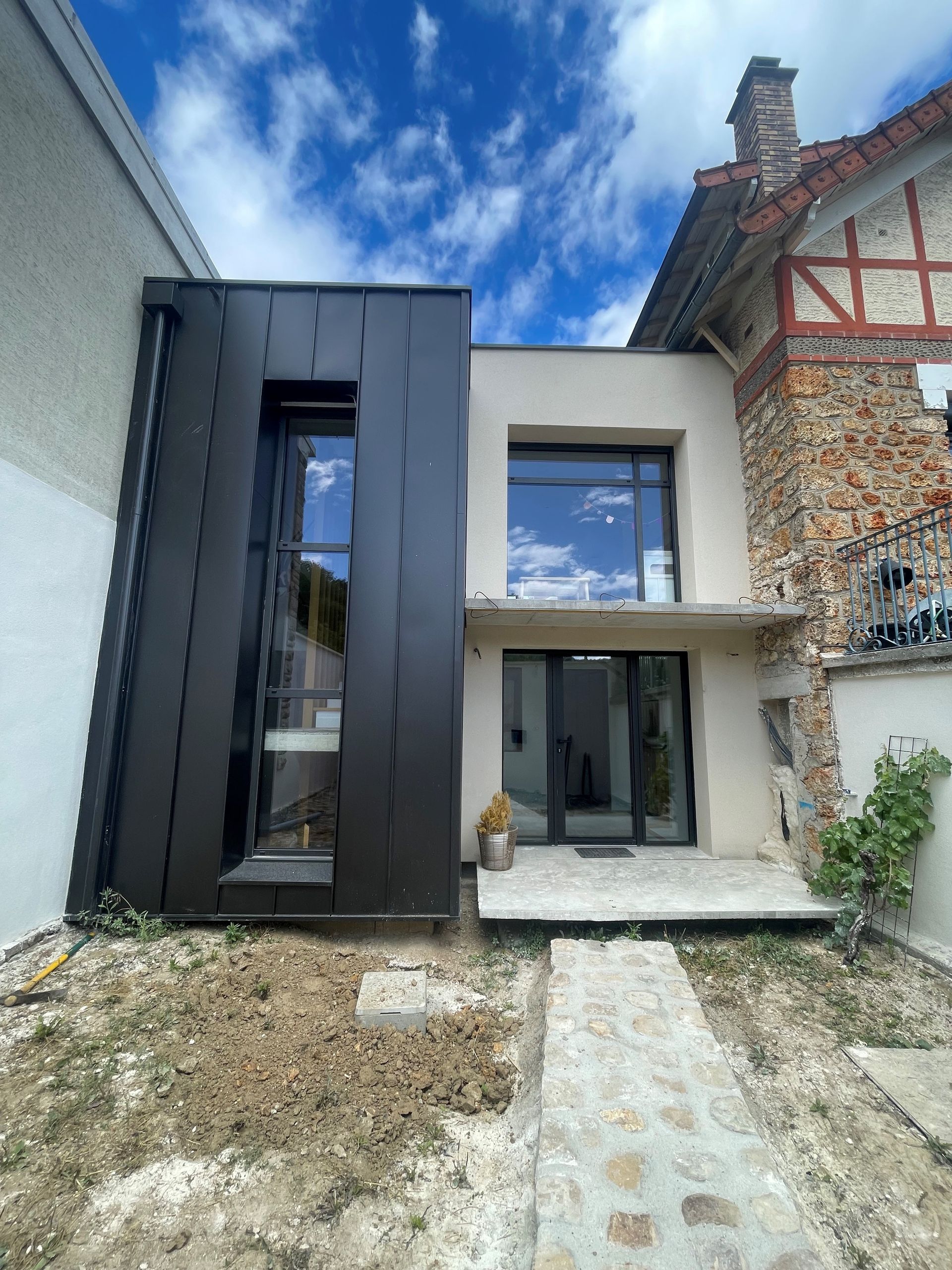 Façade d'extension en bardage aluminium et enduit.