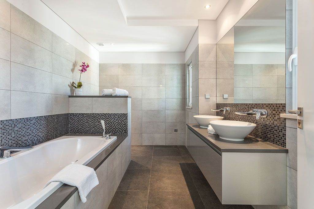 Ein Badezimmer mit Badewanne, Waschbecken und Spiegel