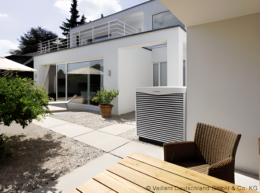 Ein weißes Haus mit einem Tisch und Stühlen davor