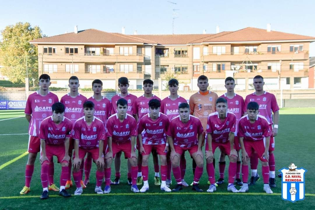 Un equipo de fútbol está posando para una foto de equipo en un campo.