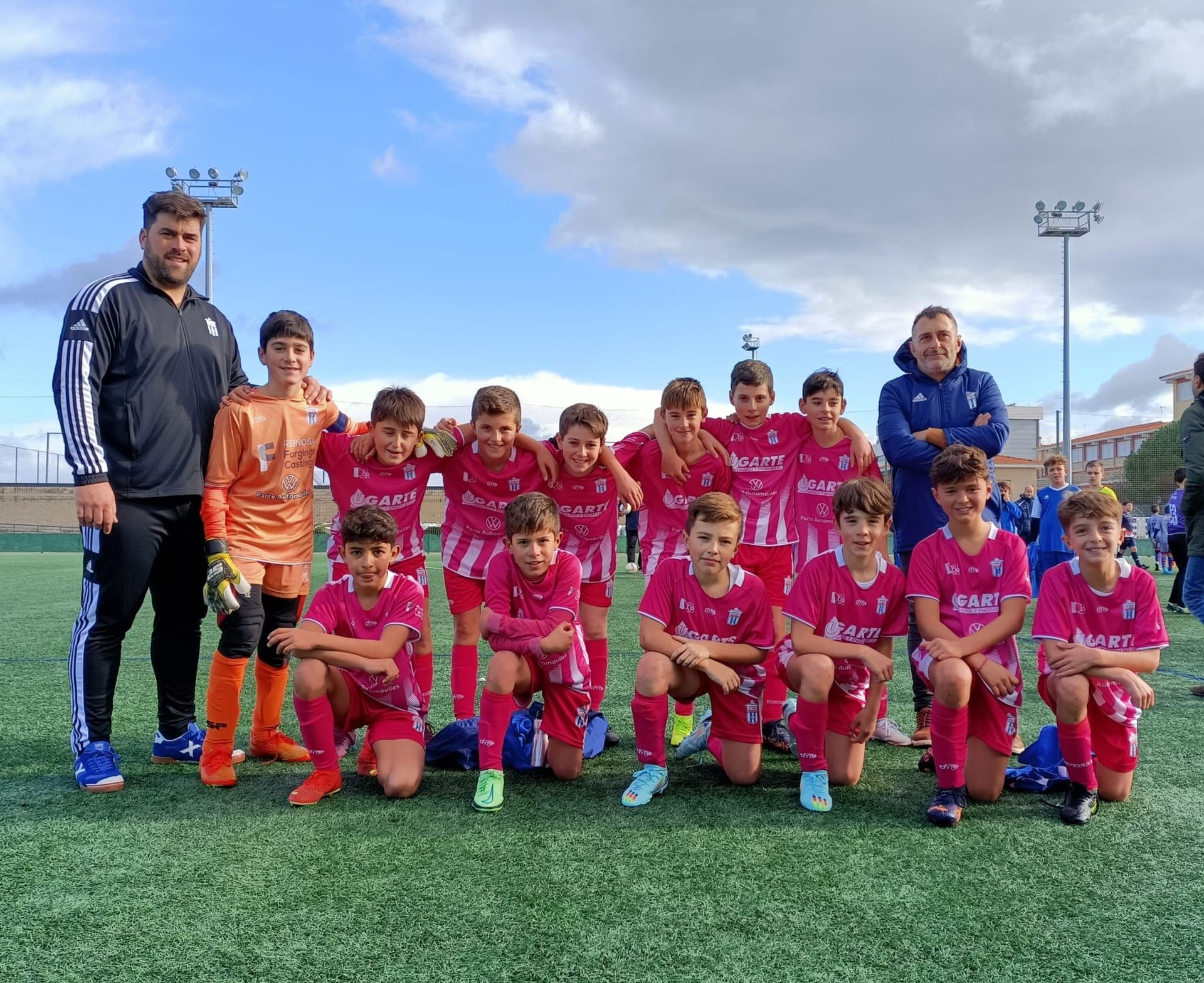 Un grupo de jóvenes posan para una fotografía en un campo de fútbol.