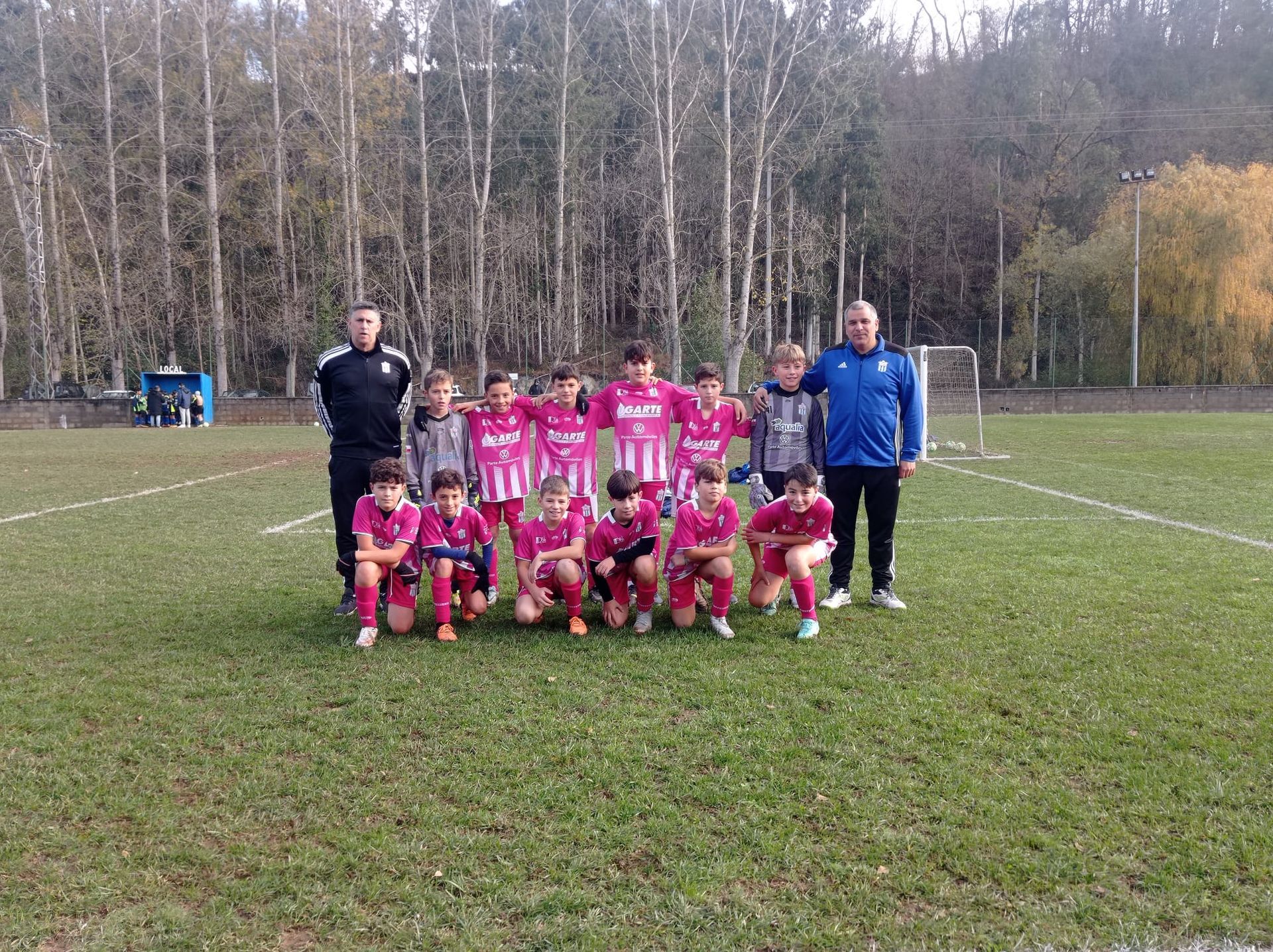 Un grupo de jóvenes posan para una fotografía en un campo de fútbol.