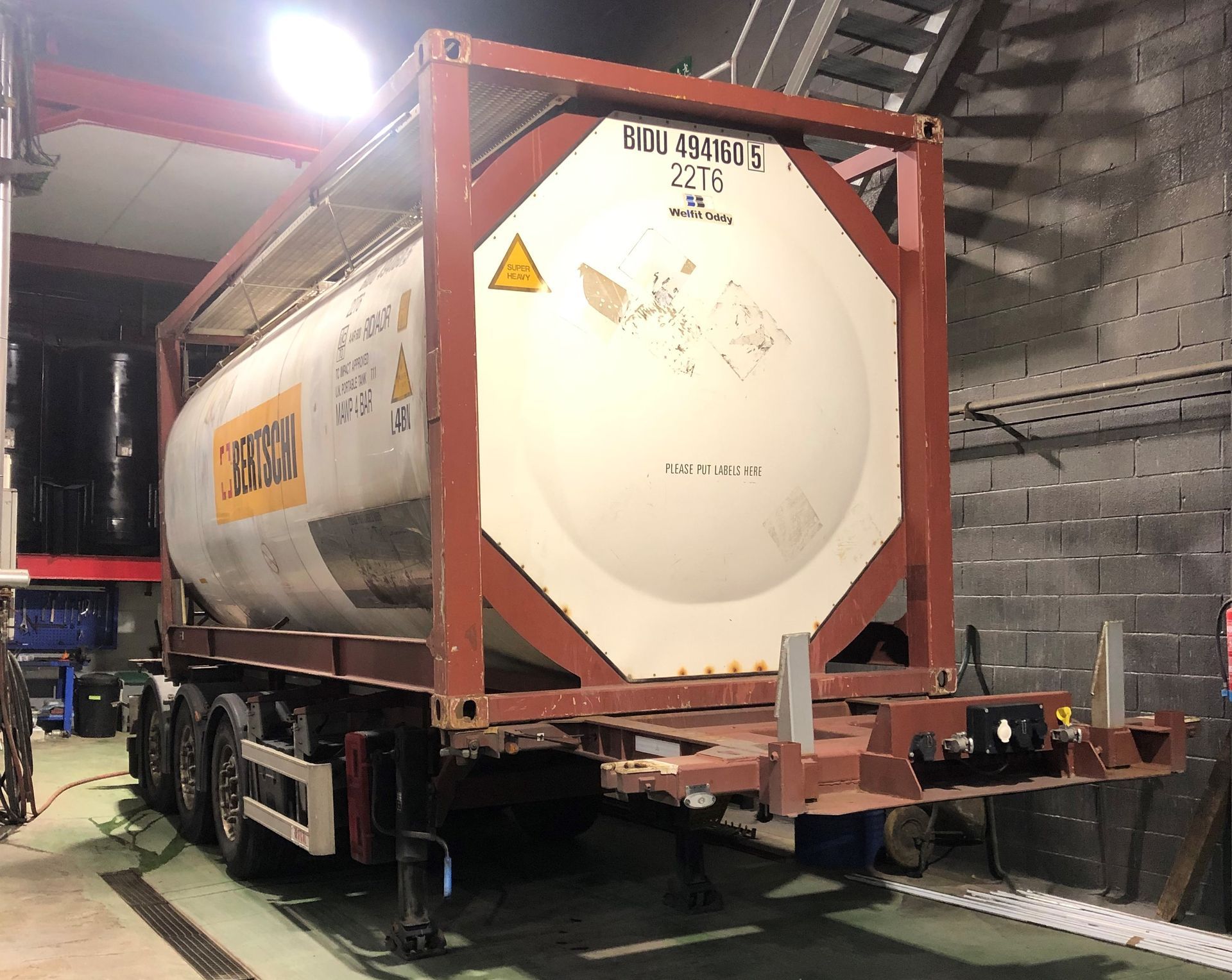 Un gran camión cisterna está estacionado en un garaje.