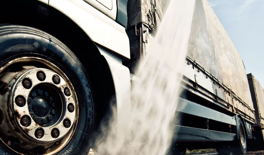 Un primer plano de un neumático de camión en una carretera.